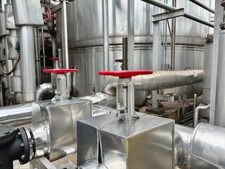 Industrial stainless steel pipeline system with red-handled gate valves. Used in HVAC, steam, and water distribution systems for factories, energy plants, or mechanical infrastructure