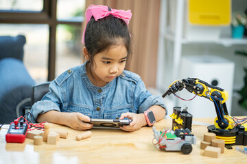 Girls learn and test robots they built in the classroom.