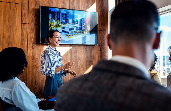 Diverse group of business people working in a meeting room discussing building design and plans. - Powered by Adobe