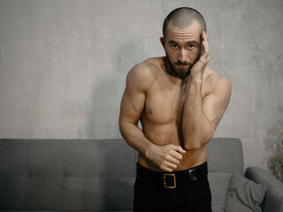 A young attractive man trains boxing at home after work.