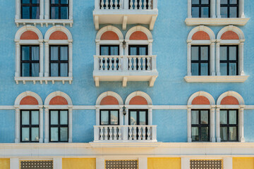Vintage windows and balconies on blue wall. facade of the building is in the Old European style of...