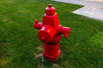 A bright red fire hydrant standing on a sidewalk, symbolizing safety and emergency response. A...