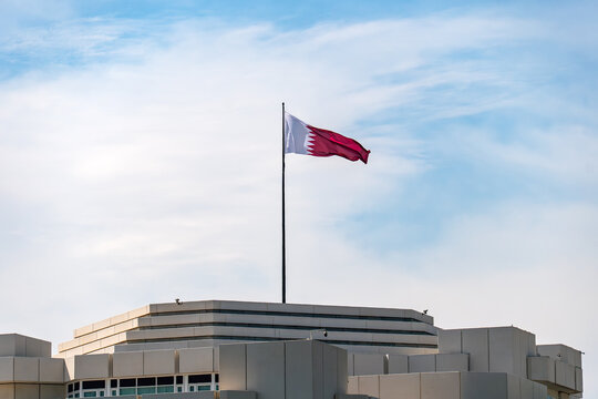 The Emiri Diwan Palace, the center of government, in Doha, Qatar. Flag on Qatar flag pole and blue sky,