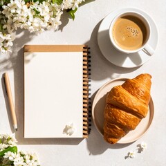 Flat lay of a breakfast scene with a coffee mug, croissant, and open notebook