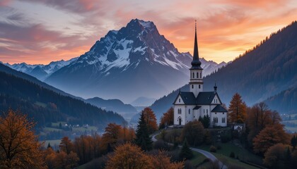 Fototapeta premium A serene sunset in the mountains colors the sky above the mountain village church.