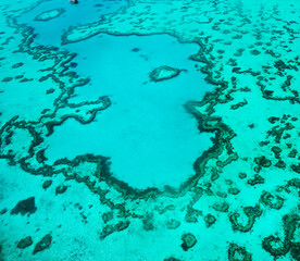 Aerial view of underwater reefs and Heart Reef of the Great Barrier Reef, the world's largest coral reef system with its clear waters, near Whitsundays Islands, Coral Sea, Australia 2020.