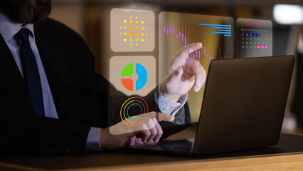 Close-up of businessman interacting with visualized data on laptop using holographic UI with pie...