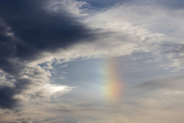 A textured cloudy sky with beautiful iridescent rainbow coloured light.
