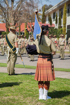 Army band member in kilt playing bagpipes in military freedom of entry parade