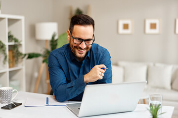 Happy entrepreneur working from home having a successful video call on laptop