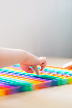 Poppet pop fidget toy being pressed by childs finger with copy space
