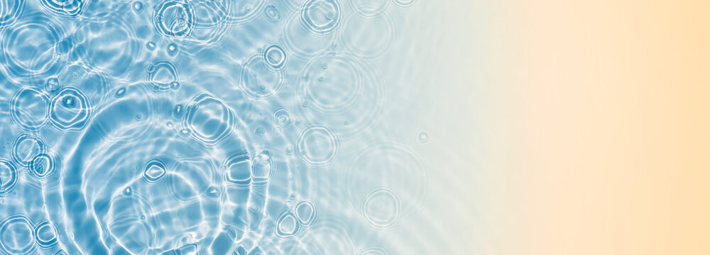 water drop circles in water surface with transparent sunlight reflections from above at abstract sand beach, beach holiday background banner concept with copy space for travel, vacation and beauty spa