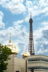 Naklejka premium Eiffel Tower rising behind golden domes of Russian Orthodox Cathedral in Paris