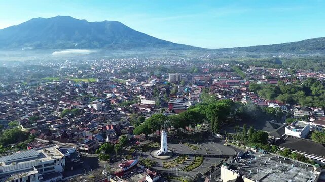 Aerial view of Jam Gadang clock tower and cityscape with Mount Marapi in Bukittinggi, West Sumatra, Indonesia.