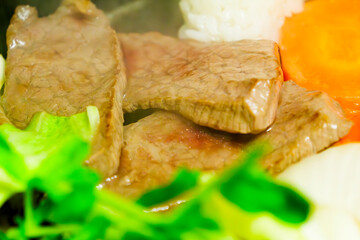 Beef, vegetables, rice balls, and yakiniku grilled on a hot plate