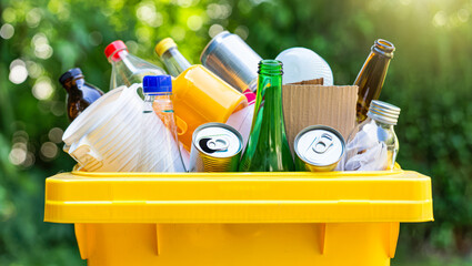 Overflowing trash bin with plastic, metal bottles, paper in a city park. Importance of sorting garbage and sustainability. eco-friendly, protection of environment