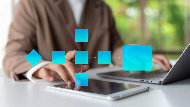 A businesswoman using a tablet to interact with a digital flowchart diagram, symbolizing process optimization, digital workflow, and project management in a modern business environment.