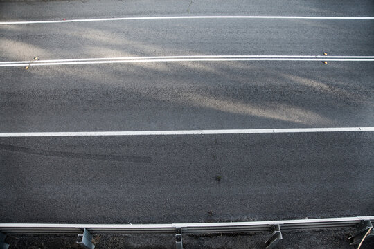 Overhead shot of unbroken white lines on a sealed road