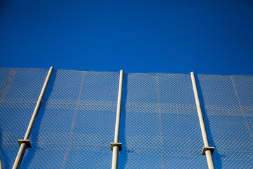 Three poles on a fence along a bridge for mine trucks