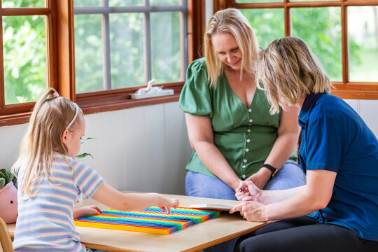 speech pathologist consulting with parent while filling out paperwork form for child
