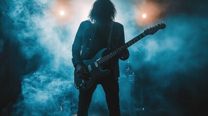 Silhouette of a guitarist performing on stage with smoke and lights.
