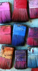 Used paintbrushes in various colors, arranged close together