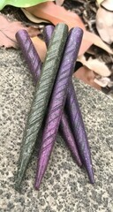 Four dark, sparkly, pointed objects, likely decorative, lie on a stone surface