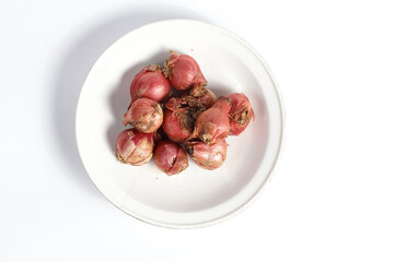 bunch of fresh shallots in a plate isolated white