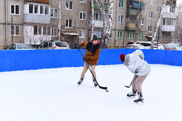 People skate and play ice hockey in the yard