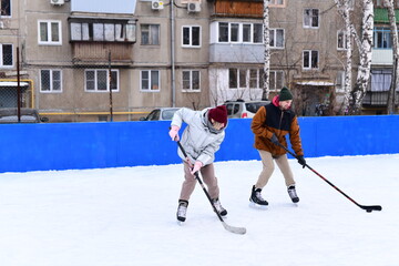 People skate and play ice hockey in the yard