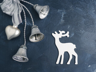 Minimalistic Christmas decoration with a reindeer and bells on a dark background, Seasonal or holiday greetings