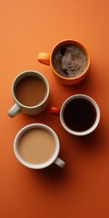 Assorted coffee cups on orange surface with foam and cream variations