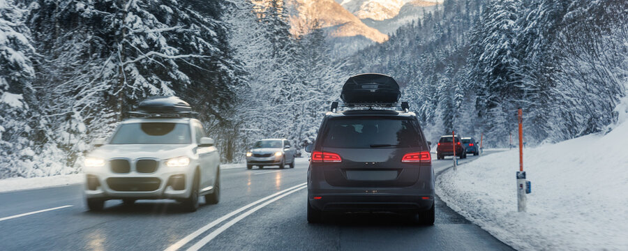 Fototapeta Scenic back view family van car roof box rack luggage drive alpine countryside road cold winter day Europe mountain resort. Automobile vehicle holidays trip journey. Vacation transport seasonal scene
