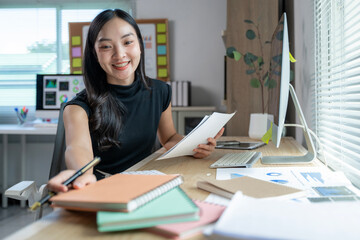 A woman is sitting at a desk with a computer monitor and a keyboard