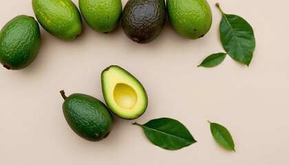 the image displays a collection of avocados and leaves arranged on a light beige background, in the foreground