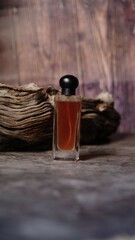 A luxury glass perfume bottle with cap containing wooden background arranged by side adding natural...