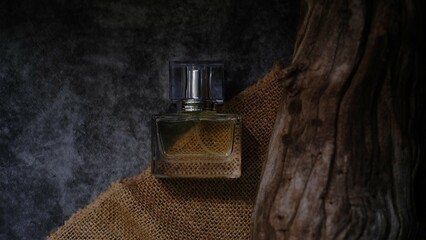 A luxury glass perfume bottle with cap containing wooden background arranged by side adding natural...