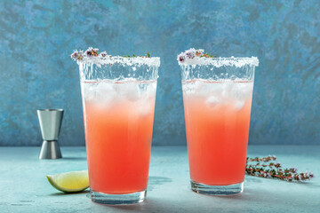 Salty Dog cocktail with fresh grapefruit juice, lime juice, and thyme, side view with a jigger