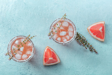 Salty Dog cocktail with fresh grapefruit juice, lime juice, and thyme, overhead flat lay shot with...