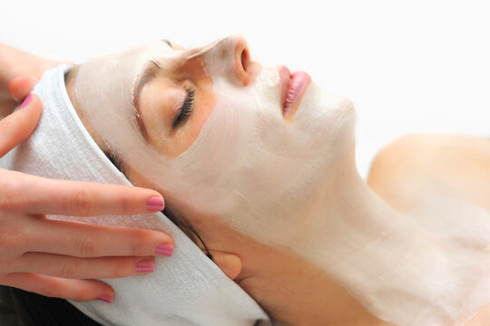 Woman relaxes as a beautician applies a fask mask during a beauty treatment
