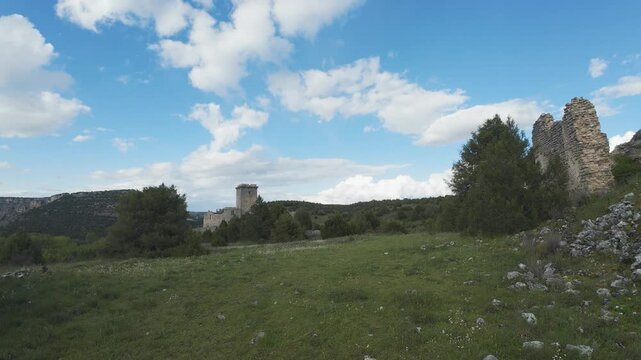 Medieval castle ruins dominating green landscape under cloudy sky