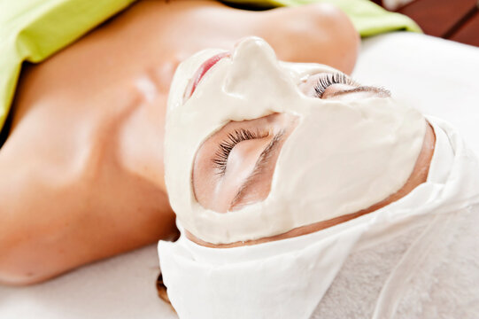 view from behind of a woman with a facial mask during a beauty treatment