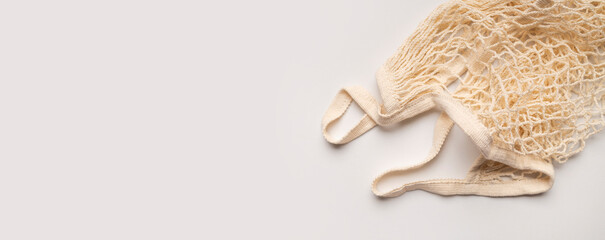 Eco-friendly string bag, shopping mesh bag of cotton threads on light gray background top view. Zero waste and plastic-free concept. Bag for buying fruits, vegetables and groceries