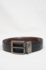 Stylish black embossed leather belt with a rotating gunmetal buckle, perfect for versatile formal...