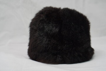 Soft, dark brown or black furry hat, offering a cozy and stylish accessory for colder weather.