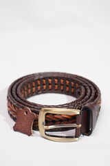 Coiled, two-tone braided brown and tan leather belt with a brass buckle and leather authenticity...
