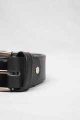 Black pebbled leather belt with a sleek silver buckle, a timeless and versatile accessory.