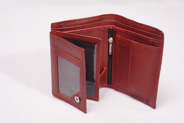 Open, deep red textured leather wallet revealing multiple card slots, an ID window, and a zippered...