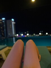 pool evening shooting knees of an unrecognizable young girl lights on the horizon