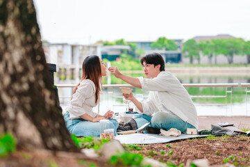 Asian Couple Sharing Snacks Outdoors